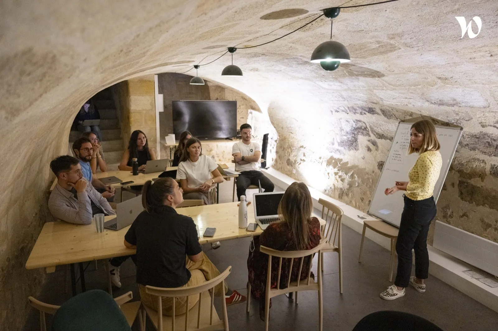 Réunion sous les voûtes en pierre, écran et escalier ancien en arrière-plan — Bordeaux Leyteire